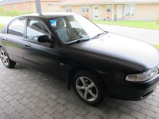 Det sorte lyn er blevet solgt - Mazda 626 fra 95 Matsort Mazda 626 fra 1995 står i et vognly