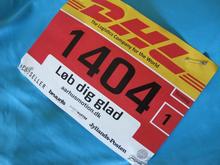 Løb dig glad med DHL Stafetten. Et billede af et DHL Stafet løbenummer, der sidder fast på en løbe t-shirt.